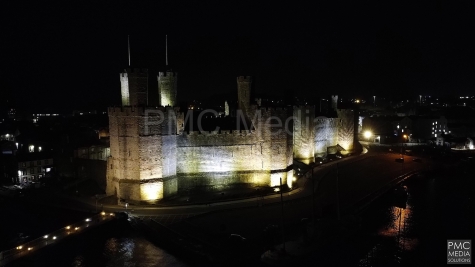 Caernarfon Castle lit up and from the air