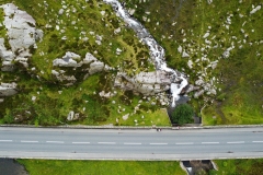 An aerial shot of a snowdonia road, mountain and waterfall.