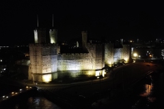 Caernarfon Castle lit up and from the air